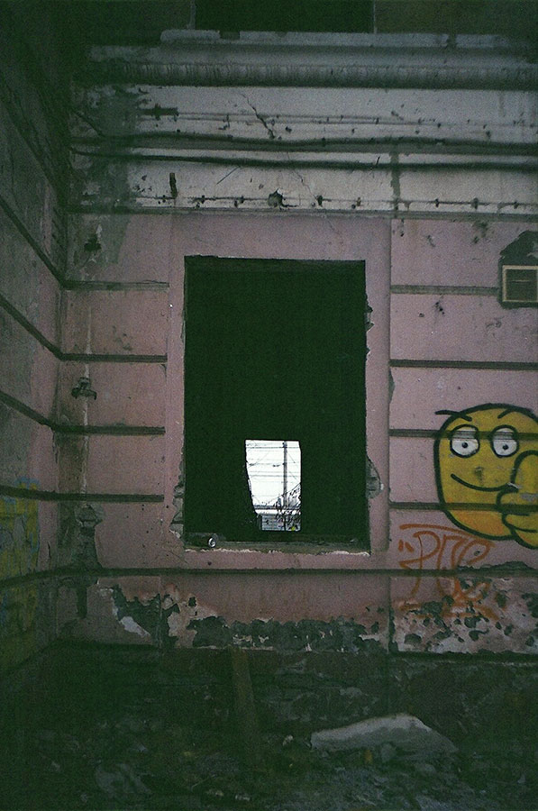 Destroyed house with a broken window taken on a Soviet film camera