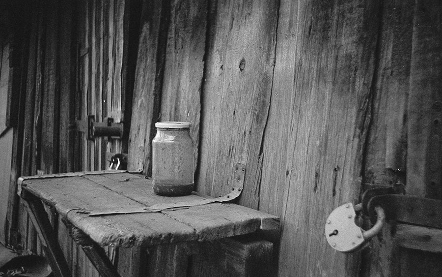 Black and white photo of an old table and jar taken with with a smena 2