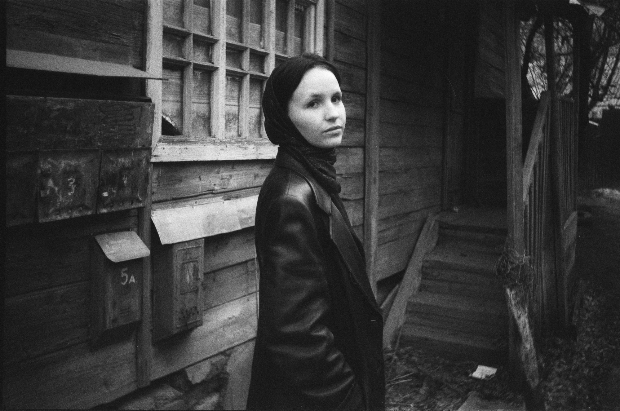 Authentic photo of a woman against an old house shot on a film camera